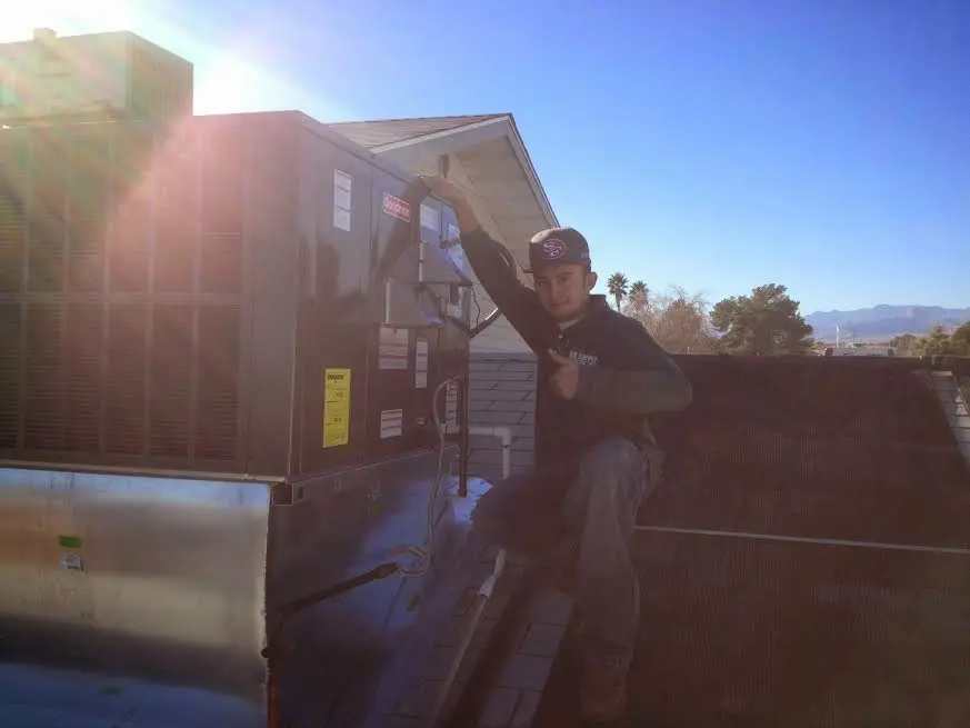 HVAC technician performing HVAC Inspection on a rooftop unit in Conewago
